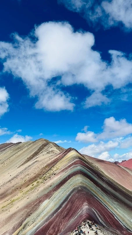 Montaña de Siete Colores ( Vinicunca ), Cusco Cumbre de la Montaña de Siete Colores o Vinicunca con sus franjas minerales bajo un cielo azul con nubes
